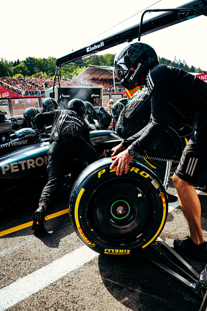 Механиците на Mercedes-AMG PETRONAS Formula One Team извършват спиране в бокса. Един от членовете подготвя гума Pirelli, докато останалите работят по колата. Марката Einhell е видима върху оборудването над автомобила.